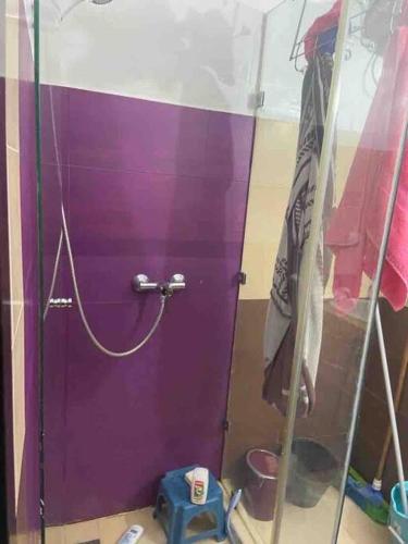 a purple door in a room with some clothes at appartement dans résidence Marrakech avec piscine in Marrakesh