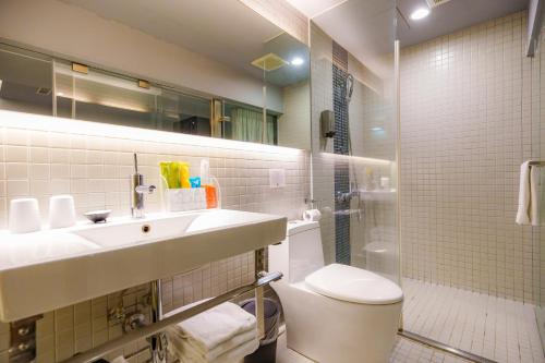 a bathroom with a sink and a toilet and a shower at 安庭台北商旅 in Taipei
