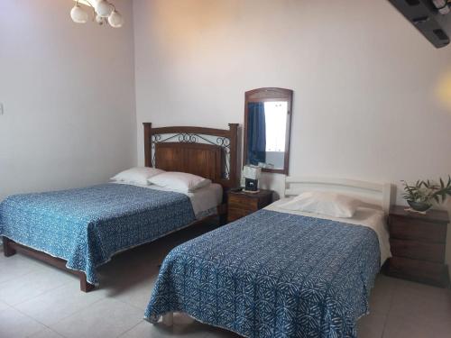a bedroom with two beds and a mirror at Montemar Apart Hotel - Playa Huanchaco in Huanchaco