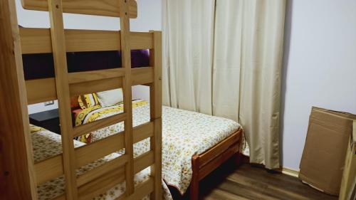 a bedroom with a bunk bed and a ladder at Cabaña en Coñaripe Sector Termas Geométricas in Coñaripe