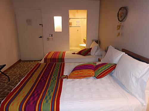 two beds sitting next to each other in a room at Hotel Casa Sattva- Bed & Breakfast in Rincón