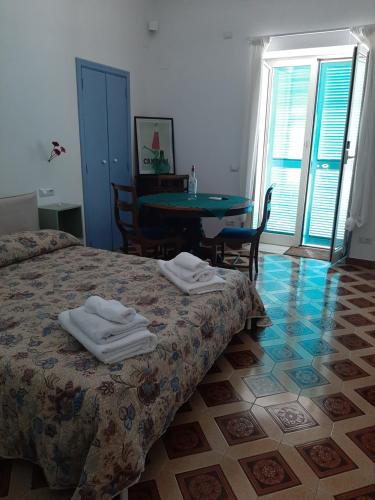 1 dormitorio con 1 cama, mesa y sillas en Dan Ravello en Ravello