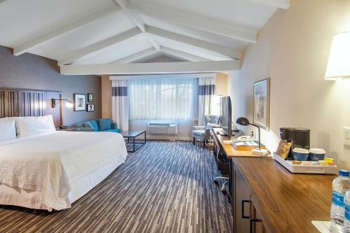 Habitación de hotel con cama y escritorio en Four Points by Sheraton Melville Long Island en Plainview