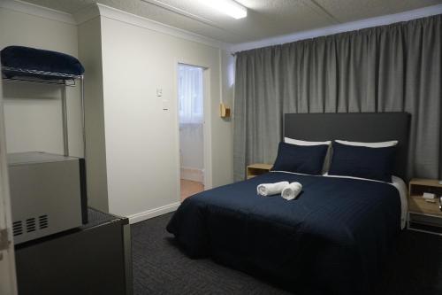 a hotel room with a bed with a towel on it at Warners Bay Hotel in Warners Bay