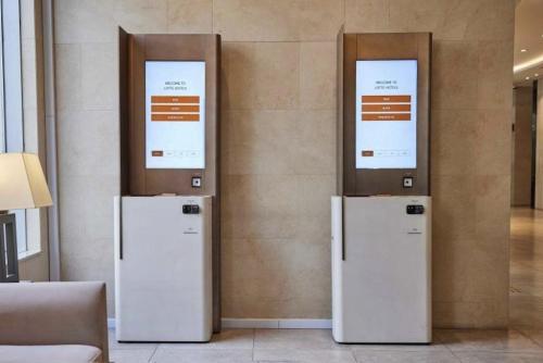 three refrigerators are lined up against a wall at LOTTE City Hotel Ulsan in Ulsan