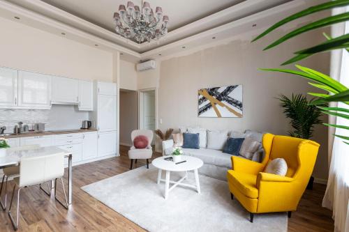 sala de estar con sofá amarillo y mesa en Luxurious Central Apartment in Liszt Ferenc Square, en Budapest