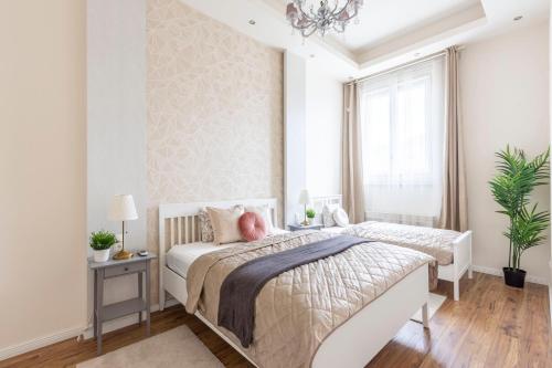 1 dormitorio con 2 camas y lámpara de araña en Luxurious Central Apartment in Liszt Ferenc Square, en Budapest