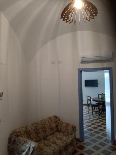 een woonkamer met een bank en een kroonluchter bij Dan Ravello in Ravello