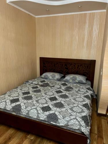 a bedroom with a bed with a black and white quilt at Квартира на березі Дніпра у новому будинку! in Cherkasy