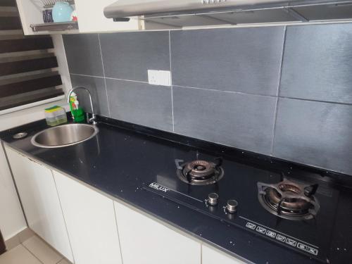 a kitchen counter with two pots on a stove at MAI Desaru Utama Residence in Bandar Penawar