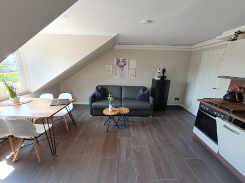 a living room with a couch and a table at Neumühler Hof- Gemütliche Wohnung "Lenia" Parkplätze und Kongresshalle in der Nähe in Schwerin