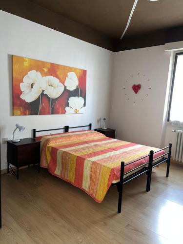 a bedroom with a bed and a clock on the wall at Palazzina Salodium INCANTO - ARMONIA - ENERGIA in Salò