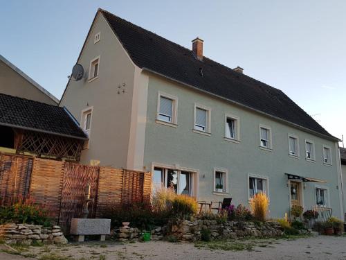 ein Haus mit einem Zaun davor in der Unterkunft Ferienwohnung Nr 4 in Litzendorf