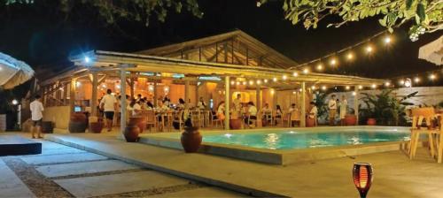 a group of people sitting around a pool at night at Bungalow Cafe Gili Beachfront in Gili Meno