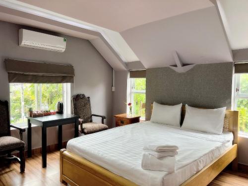 1 dormitorio con 1 cama y escritorio en una habitación en Lilac Cottage Homestay, en Phu Quoc