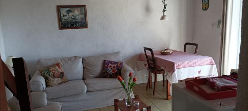 a living room with a white couch and a table at La Mez a Nine gîtes in Buxières-sous-Montaigut