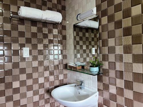 baño con lavabo y pared de azulejos en Lilac Cottage Homestay en Phu Quoc