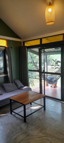 um quarto com uma mesa de centro, uma cama e uma janela em บ้านลูกจัน Bann Lookjan Trat em Trat
