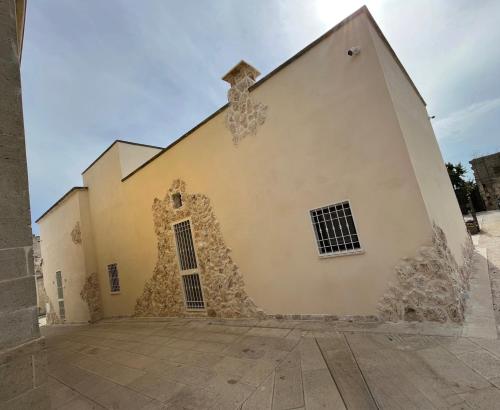 un gran edificio con ventanas laterales en Antica Dimora "Lu suli, Lu mari, Lu jentu", en Monacizzo