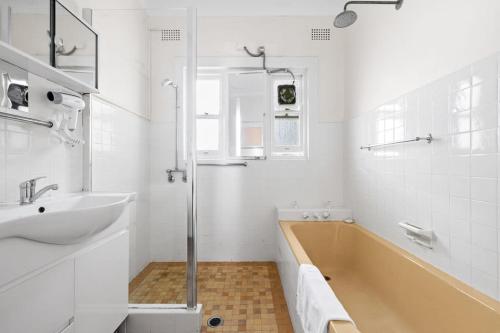 a bathroom with a tub and a sink and a shower at Signature Queen Room in Auburn in Sydney