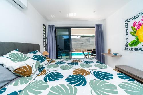 1 dormitorio con 1 cama con edredón azul y blanco en Fare Fafapiti Mataiea wPool, en Otutara