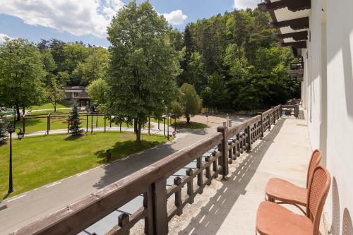 einen Balkon mit Bänken und Parkblick in der Unterkunft Hotel Central in Călimăneşti