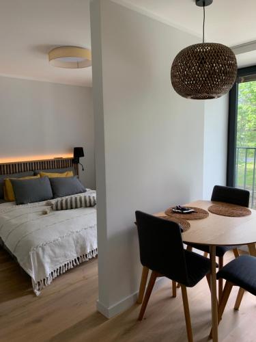 a bedroom with a bed and a table and chairs at Seaside apartment Albatross, 16 in Ķesterciems