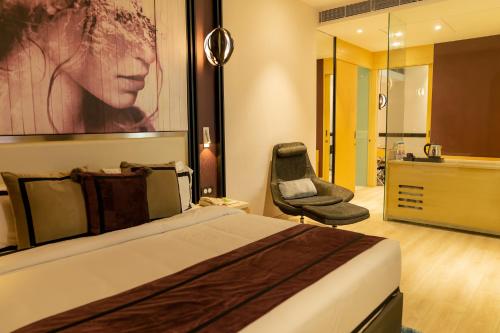 a hotel room with a bed and a chair at BEYZAA HOTEL AND SUITES in Kolkata
