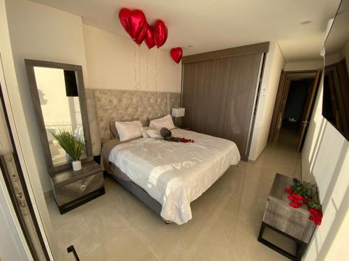 a bedroom with a bed with red hearts on the wall at Camino al Mar in Mazatlán