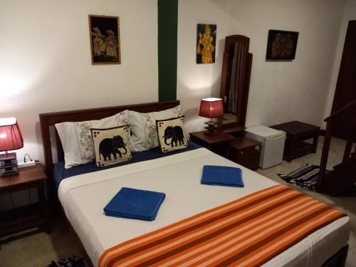 a bedroom with a bed with two blue towels on it at The Nature Park Villa in Sigiriya