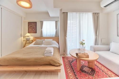 a bedroom with a bed and a table and a couch at TORA HOTEL Sensoji 寅ホテル 浅草寺 in Tokyo