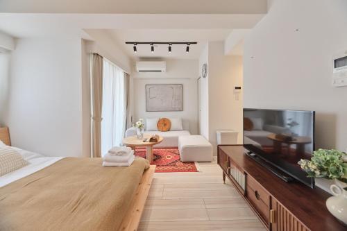 a bedroom with a bed and a living room at TORA HOTEL Sensoji 寅ホテル 浅草寺 in Tokyo