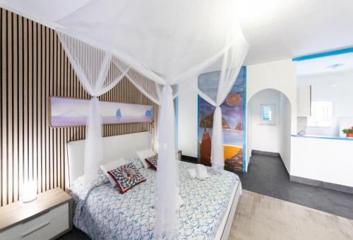 - une chambre avec un lit blanc à baldaquin dans l'établissement Holiday Eolie Village, à Vulcano