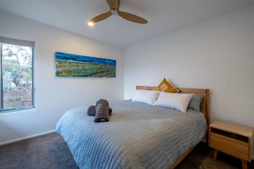 een slaapkamer met een bed en een plafondventilator bij Margaret River Coastal Apartments in Prevelly