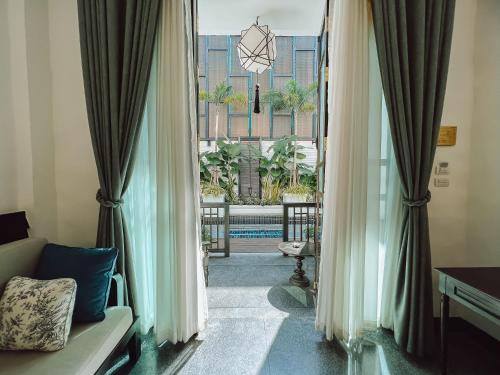 a room with a view of a pool through curtains at Thai Akara - Lanna Boutique Hotel in Chiang Mai