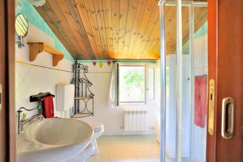 a bathroom with a sink and a toilet and a window at Villa Patty in Pian di Mulino
