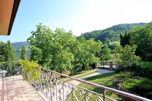 a balcony of a house with a view of a garden at Villa per gruppi fino a 20 persone, con piscina privata, camino e grande giardino nelle colline marchigiane in Pian di Mulino