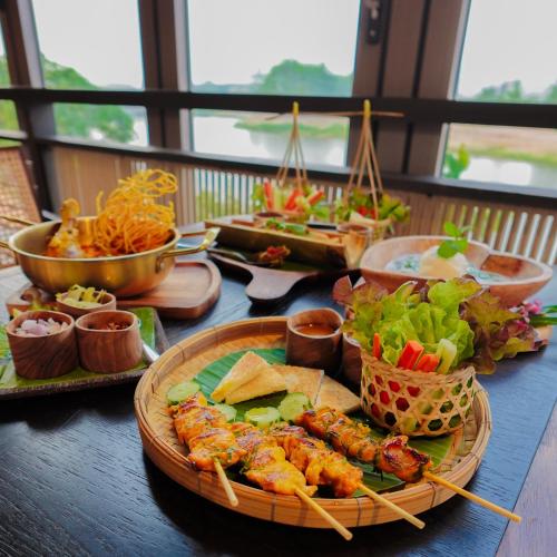 a table topped with plates of food on a table at Patamma Hideaway Resort in Nan