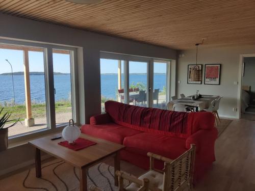 a living room with a red couch and a view of the ocean at Villa Kolmården in Kolmården