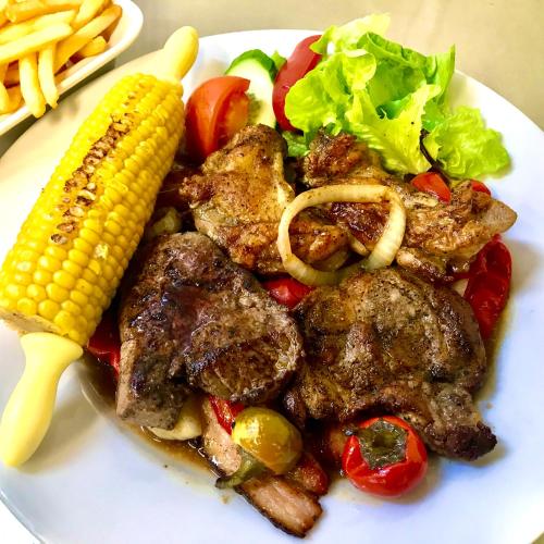 a plate of food with meat and corn and vegetables at Hotel Bílý Beránek Kralovice in Kralowitz