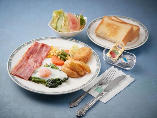 two plates of breakfast food with eggs bread and toast at Crown Hotel Okinawa in Okinawa City