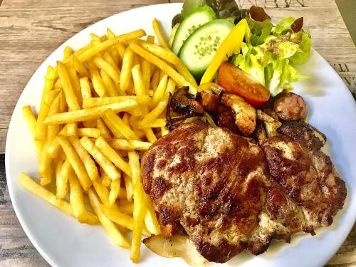 a plate of food with french fries and meat and vegetables at Hotel Bílý Beránek Kralovice in Kralowitz