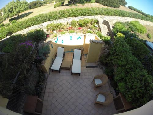 una vista aérea de un patio con bancos y una piscina en Luxury Apartment Sardegna, en Marina di Portisco