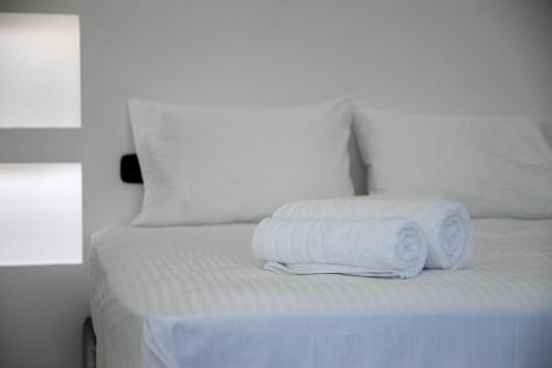 two towels are stacked on top of a bed at SithoniaRS Luxury 2nd Floor Roofgarden Apartment With Unique Seaview in Neos Marmaras