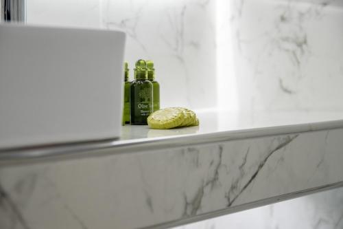 a bathroom counter with a bottle of perfume and a bread at SithoniaRS Luxury 2nd Floor Roofgarden Apartment With Unique Seaview in Neos Marmaras