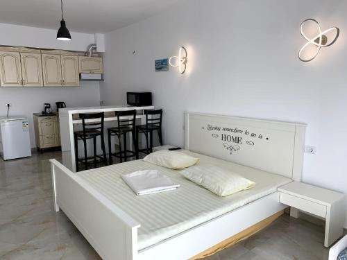 Cama blanca en habitación con cocina en EFORIE STUDIOS, en Eforie Nord