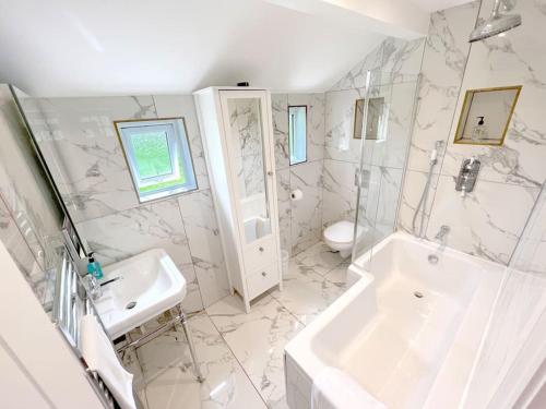 a white bathroom with a sink and a toilet at Magnolia Cottage - Kent in Lyminge