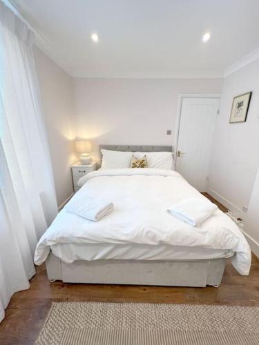 a white bedroom with a large white bed at Magnolia Cottage - Kent in Lyminge