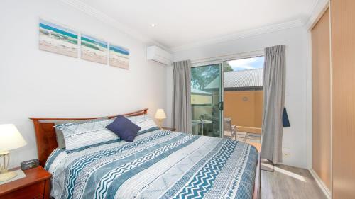 a bedroom with a bed and a large window at Riverview Apartment 2 Block 2 in Iluka