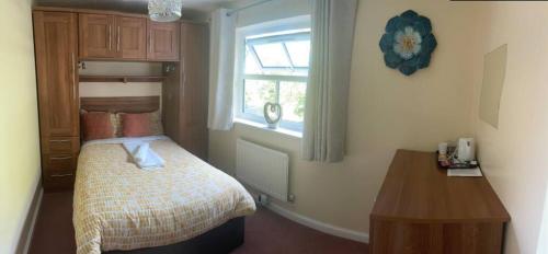 ein kleines Schlafzimmer mit einem Bett und einem Fenster in der Unterkunft 1 small double room in a cul de sac classy area in a shared house in Bristol